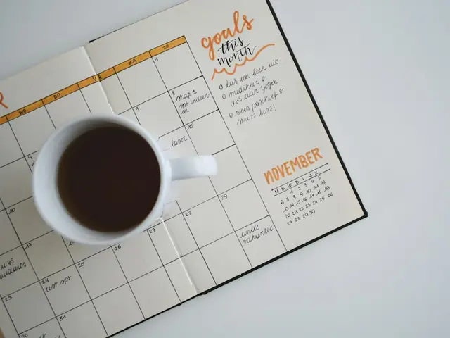 Agenda mensual abierta junto a una taza de café